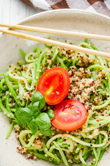 zucchini noodles with quinoa on a white background