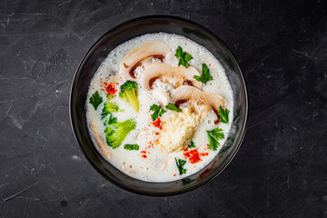 creamy mushroom soup with champignons on a black background