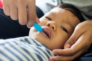 Boy doesn't like brushing his teeth and is sad, baby with her mother and brushing teeth