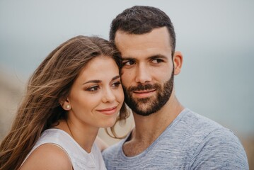 A man and his girlfriend are cuddling up to each other on a rocky hill in Spain