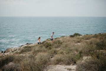 Fototapeta na wymiar A Hispanic man and his Latina girlfriend are hiking near the sea in Spain.