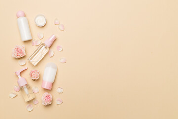 Set of small cosmetic bottles on color background, top view