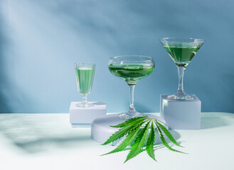 Green SBD hemp drink on creative modern podium, blue hard shadows background, cannabis cocktail