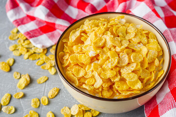 crispy golden cornflakes on a gray concrete background