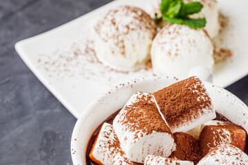 hot chocolate with marshmallows and ice cream balls on a black background