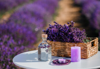 Obraz na płótnie Canvas Basket with beautiful lavender in the field in Provance with Lavander water and candles. Harvesting season