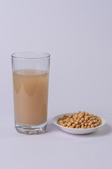 Soy bowl and soy drink on a glass, on a white table
