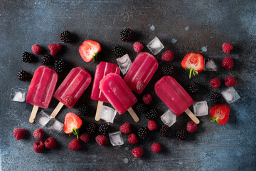Ice cream popsicle berries with ice cube on dark background
