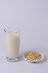 Quinoa bowl and quinoa drink on a glass, on a white table