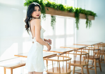 Fototapeta na wymiar Portrait beautiful asian freelance Success people business woman fashion model in summer white sleeveless dress and coffee in cup in coffee shop.