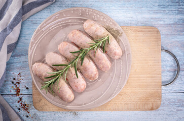 Traditional steamed white sausage on a plate, on a wooden background. Composition with white sausage, easter delicacy.