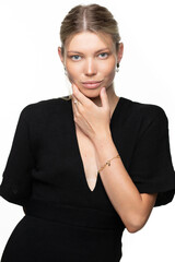 Obraz premium Fashion portrait of a charming white caucasian girl with jewelry in black clothes on a white isolated background