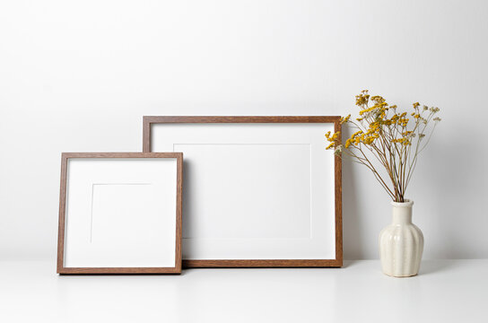 Two wooden frames mockup in white minimalistic room with copy space for artwork, photo or print presentation