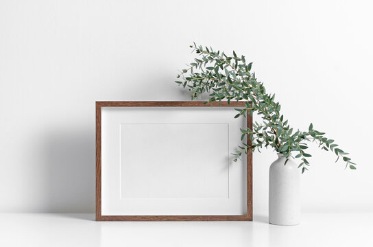 Wooden landscape frame mockup in white room interior