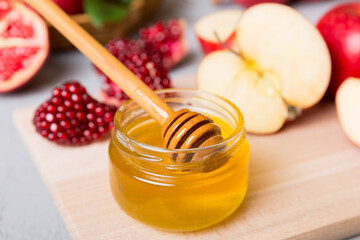 Rosh hashanah, jewish holiday, concept: honey, apple and pomegranate with cutting board, close up