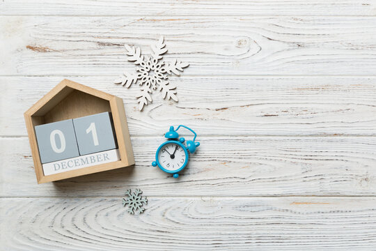 Christmas wood calendar with new year decorations, aganist colored background. Christmas calendar 1 december