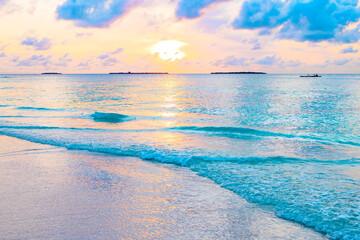 picturesque sunrise in the Maldives island, the sun rising from the Indian ocean and reflected in...