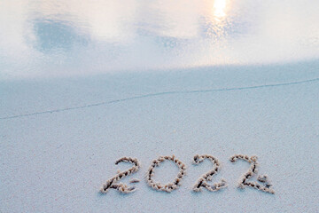 handwritten inscription 2022 on the sand by the sea