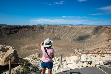 A Beautiful mature Woman taking a picture of Meteor Crater - Powered by Adobe