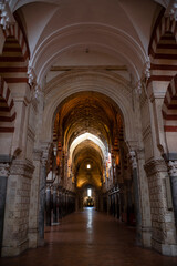 Fototapeta premium CÓRDOBA, SPAIN - APRIL, 2016. Arches Pillars Mezquita Cordoba Spain. Created in 785 as a Mosque, was converted to a Cathedral in the 1500. 850 Columns and Arches. Painted and striped arches.