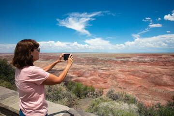 A Beautiful mature Woman Exploring the Painted Desert and Petrified Forest Taking Pictures