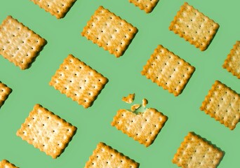 On a green isolated background, an airy crumbly cracker biscuit lies in a chaotic manner.  Close-up, background image, pattern.  The concept of delicious food.