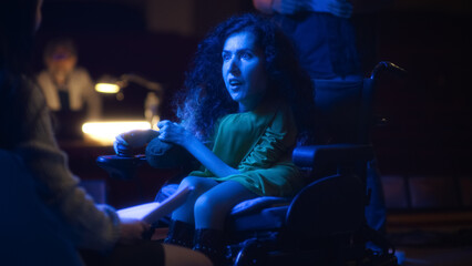 Fototapeta na wymiar Actress with disability in play rehearsal emotionally acting in wheelchair on theater stage with a group of actors and director