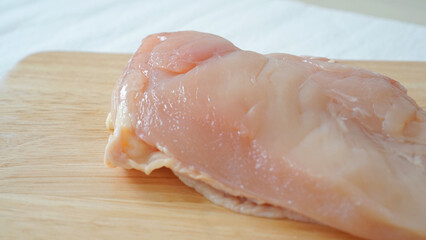 まな板に置かれた調理前の生の鶏胸肉