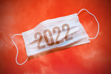 Lettering 2022 and medical mask. The return of the coronavirus. A new jump in the incidence of the...