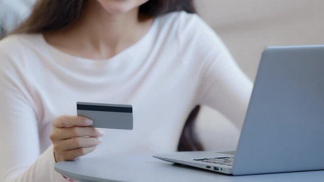 Close-up female hands unknown woman consumer freelancer holds plastic credit card paying order in web store makes donation transfers savings online booking food delivery use internet virtual bank app