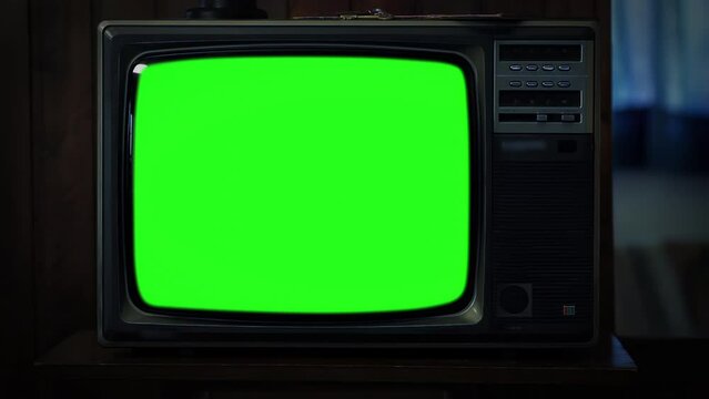 Old Television Set Green Screen in Dark Room. Closeup. Zoom Out. You can replace green screen with the footage or picture you want. You can do it with &ldquo;Keying&rdquo; effect in After Effects. 4K.