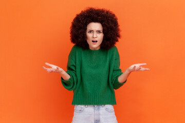What do you want? Woman with Afro hairstyle wearing green casual sweater asking who why make this...