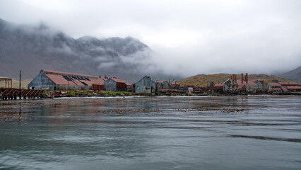 Obraz premium Derelict, rusted buildings along the shore at the old whaling station at Leith Harbor, South Georgia Island