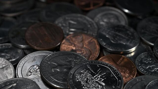 Low angle close up of slow moving United States currency in coin. 