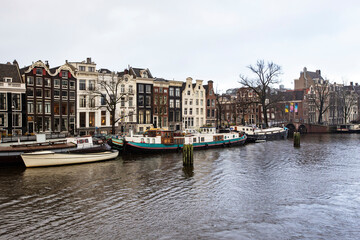 Fototapeta premium Traditional Amsterdam houseboat on the water in Amsterdam downtown, Netherlands