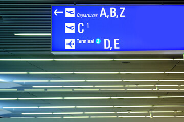 close-up of the airport hall with signboards, blue plates indicate the gate number, terminal number, signposts at Frankfurt Airport in Germany indicate the correct gate for boarding the flight
