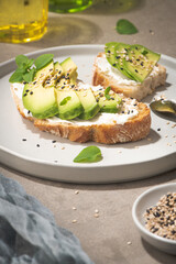 Healthy toast with avocado cream cheese and wheat bread on a plate. Delicious snacks and avocado sandwiches. Food composition, tasty Italian meal.