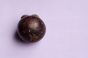 Mangosteen or purple mangosteen isolated on light purple background