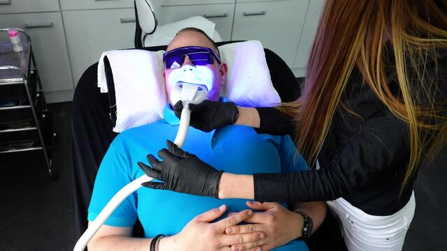 Man getting his Teeth Whitened at the dentist office - Handheld shot