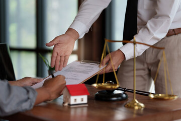Business person and lawyers discussing contract papers with brass scale on wooden desk in office. Law, legal services, advice, Justice concept.