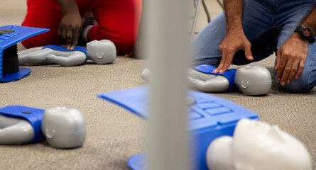 Staff practicing first aid cpr with their fingers and AED machine