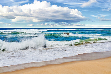 Waves rolling and crashing the shore at the beach during a summer day outside. Sea, ocean current...