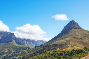 Naklejka na ściany i meble View of mountains with a path and cityscape against blue sky copyspace. A peaceful mountain with a scenic background in quiet Lions Head in Cape Town, South Africa. Nature backdrop with a hill top