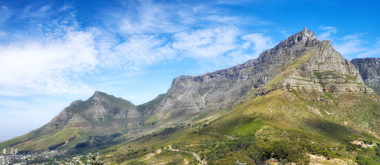 Fototapeta na wymiar Panoramic view of Table Mountain against a cloudy blue sky with copyspace. Vibrant, beautiful landscape of nature. A popular location in Cape Town for travel, hiking and adventure