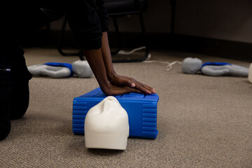 Staff practicing first aid cpr with their fingers and AED machine - obrazy, fototapety, plakaty
