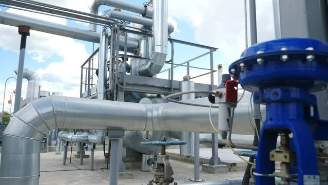 Chemical plant pipelines. Heavy industry. Large industrial tubing and piping inside central heating plant. Steam heat exchangers. Degassing channels. Interior industrial gas boiler with piping, pumps