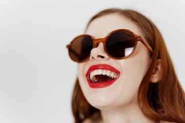 Laughing red-haired girl with glasses coat on a white background in the studio. Advertising for showroom, designer clothes