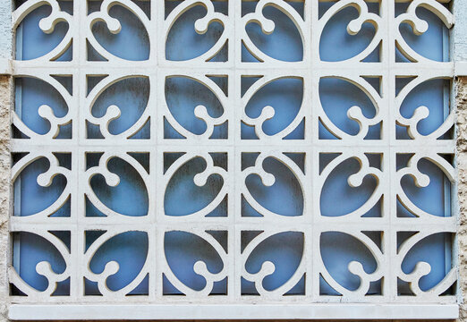 Texture of forged metal lattice against blue window, background