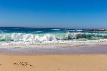 A view on Pacific ocean coast with blue sky and water and waves