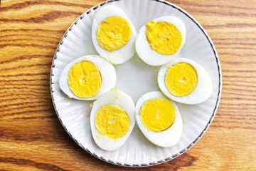 Half boiled eggs laid out in white plates and served on a wooden table.flat lay, Top view.